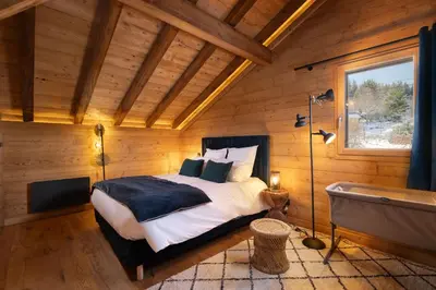 Un ou plusieurs lits dans un hébergement de l'établissement Chalet Tharkey, luxueux au coeur des sapins