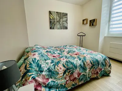 Un ou plusieurs lits dans un hébergement de l'établissement Joli appartement avec parking