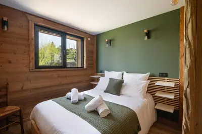 Un ou plusieurs lits dans un hébergement de l'établissement Chalet Bellevue, piscine intérieure, spa, vue lac