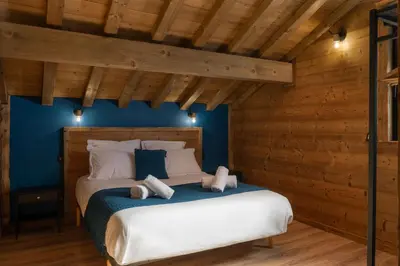 Un ou plusieurs lits dans un hébergement de l'établissement Chalet Bellevue, piscine intérieure, spa, vue lac