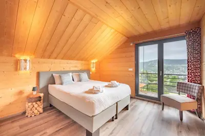 Un ou plusieurs lits dans un hébergement de l'établissement Chalet La Souris, chaleureux avec vue panoramique