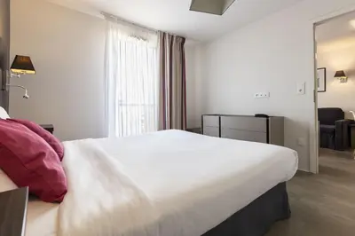 Un ou plusieurs lits dans un hébergement de l'établissement Appart'hôtel Odalys City - Colmar Centre