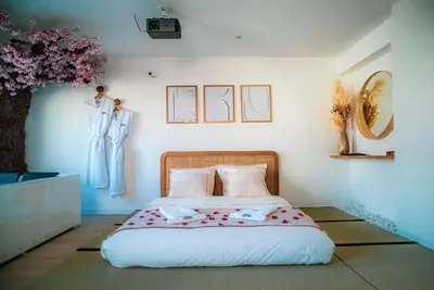 Un ou plusieurs lits dans un hébergement de l'établissement Nuit romantique, Suite avec jacuzzi et cinéma privé au design Japandi