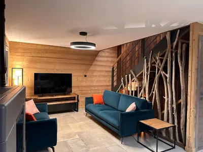 Coin salon dans l'établissement Chalet PLUME D'EAU - jacuzzi, piscine et pétanque