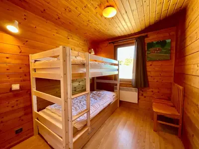 Un ou plusieurs lits dans un hébergement de l'établissement Chalet Les 3 Lueurs, authentique au pied de pistes