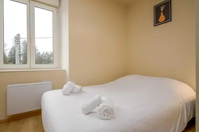 Un ou plusieurs lits dans un hébergement de l'établissement Le 61-Appart'Hôtel-GregIMMO