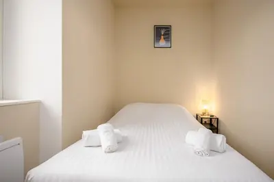 Un ou plusieurs lits dans un hébergement de l'établissement Le 61-Appart'Hôtel-GregIMMO