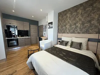 Un ou plusieurs lits dans un hébergement de l'établissement Appart Hôtel la roseraie
