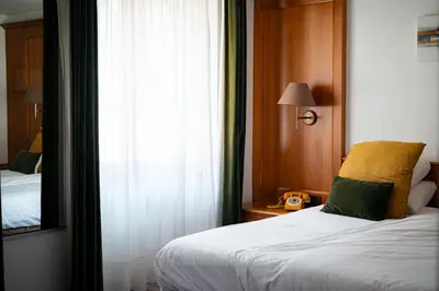 Un ou plusieurs lits dans un hébergement de l'établissement Hôtel Le Rapp