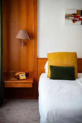Un ou plusieurs lits dans un hébergement de l'établissement Hôtel Le Rapp