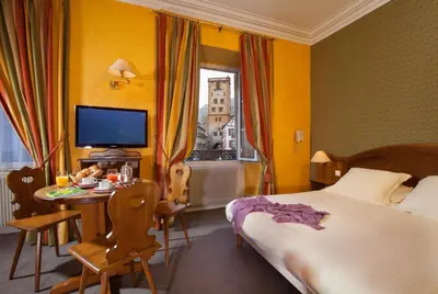 Un ou plusieurs lits dans un hébergement de l'établissement Logis Hôtel de la Tour