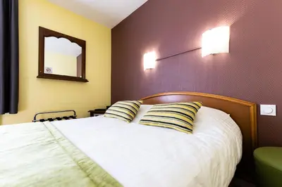 Un ou plusieurs lits dans un hébergement de l'établissement Hotel Cheval De Bronze