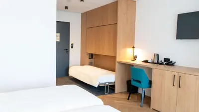 Un ou plusieurs lits dans un hébergement de l'établissement Brit Hotel Grand Hotel Munster