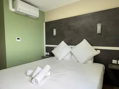 Un ou plusieurs lits dans un hébergement de l'établissement Contact Hôtel Arc-En-Ciel - Réouverture - Rénové