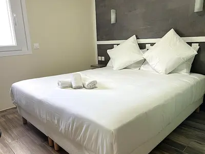 Un ou plusieurs lits dans un hébergement de l'établissement Contact Hôtel Arc-En-Ciel - Réouverture - Rénové