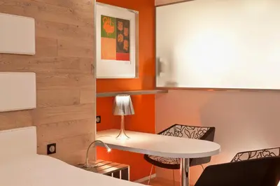Un ou plusieurs lits dans un hébergement de l'établissement Hotel Le Colombier Suites