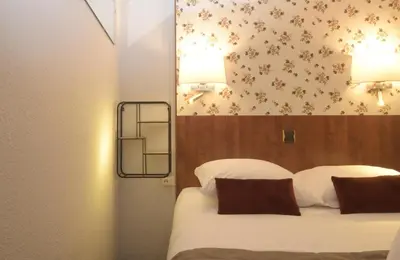 Un ou plusieurs lits dans un hébergement de l'établissement Hotel Arc-En-Ciel Colmar Contact Hotel