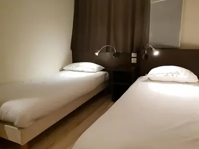 Un ou plusieurs lits dans un hébergement de l'établissement Cit'Hotel Primo Colmar Centre