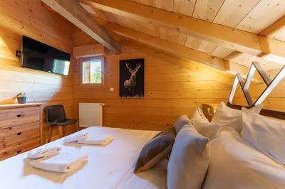 Un ou plusieurs lits dans un hébergement de l'établissement Chalet des Cîmes, chaleureux avec jacuzzi et sauna