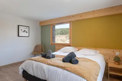 Un ou plusieurs lits dans un hébergement de l'établissement Chalet L'Urson, spacieux, jacuzzi, hammam et sauna