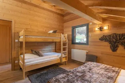Un ou plusieurs lits dans un hébergement de l'établissement Chalet Mana, tout confort avec spa et sauna