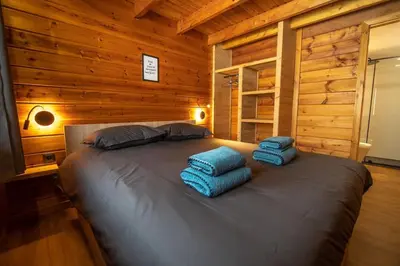 Un ou plusieurs lits dans un hébergement de l'établissement Pétillant Chalet aux 3 étangs avec SPA, Sauna et Véranda